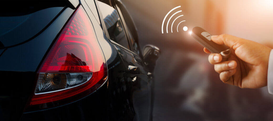 hand pressing car key remote control to unlock